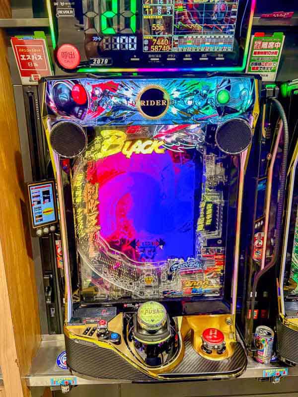Tokyo Free Walking Tours: 3 Tours I Tried and Recommend 20 A brightly lit Japanese pachinko machine with colorful graphics, digital displays, and control buttons in an arcade setting.