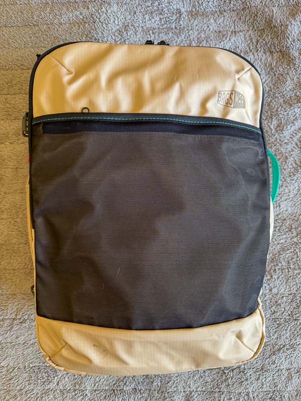 BAGSMART BLAST Series Review: Tested on My Travels 5 A beige and black Blast 40L Rucksack with a front zip pocket sits on a textured grey surface. The rucksack features the “BAGSMART” logo on the top right corner.
