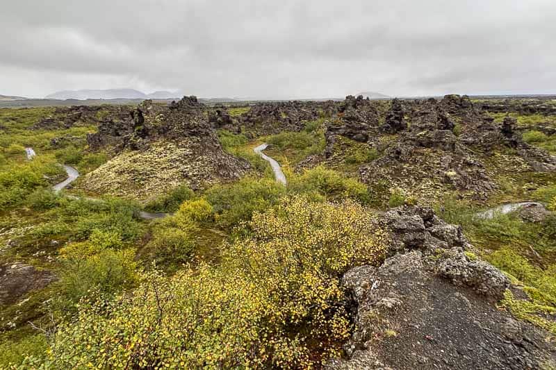 The Diamond Circle: Iceland's Other Scenic Drive 10 Winding path through a rocky, moss-covered lava field with scattered green and yellow vegetation under a cloudy sky—an iconic scene from 10 days in Iceland.