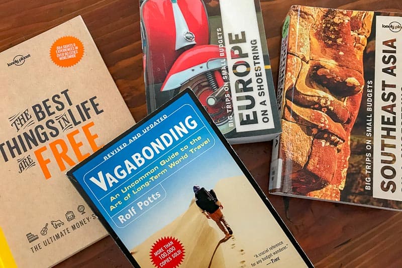 Do You Still Need Travel Guidebooks? 2 Four travel books are spread out on a surface, including titles about travelling for free, Europe, Southeast Asia, and long-term world travel. Each book features colourful covers with images and text.
