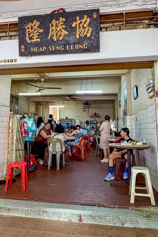 Where to Eat Kaya Toast in Singapore: 9 Places I've Tried 16 People sit at plastic tables and chairs inside a casual eatery named Heap Seng Leong. The interior is simple with tiled walls and fans hanging from the ceiling. A few people are eating or talking.