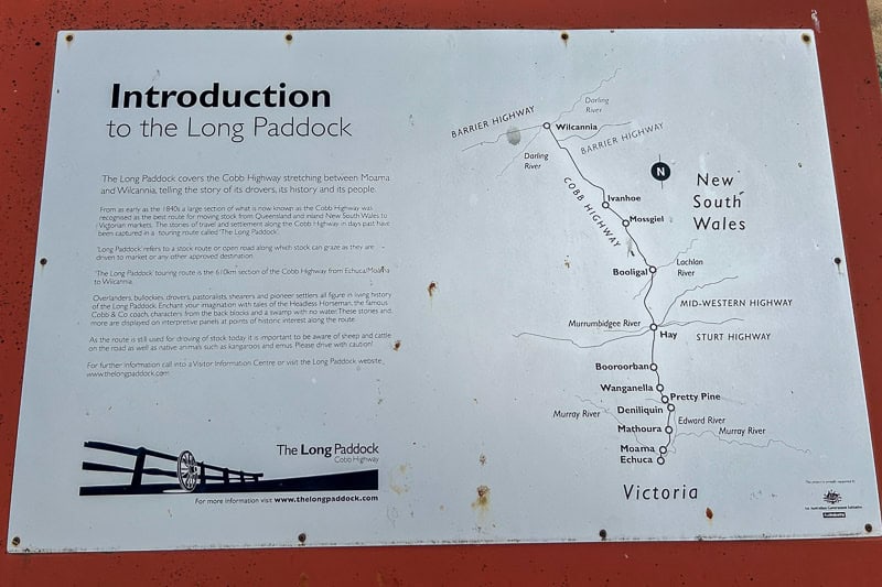 13 Things to Do in Hay, NSW 12 A sign explaining the Long Paddock with a black and white map showing the Cobb Highway from Wilcannia to Echuca, labelling towns along the route in New South Wales and Victoria. Text provides historical information.
